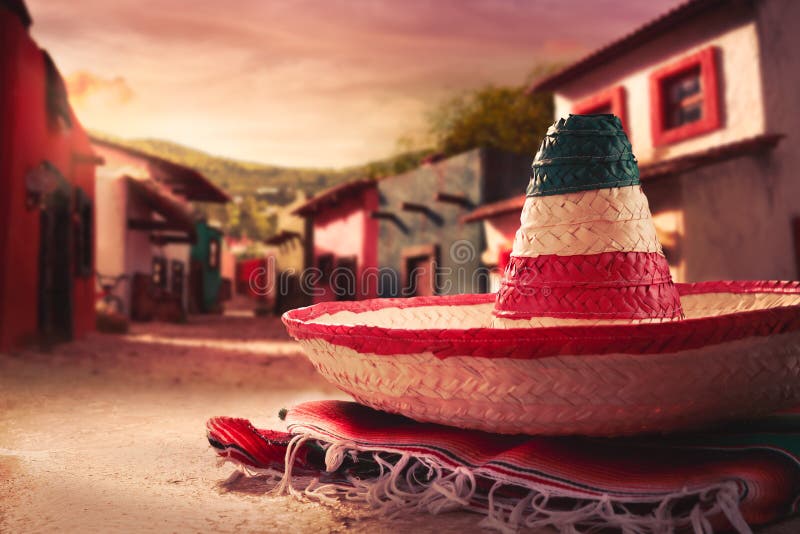 Mexican hat sombrero on a serape in a mexican town at sunset