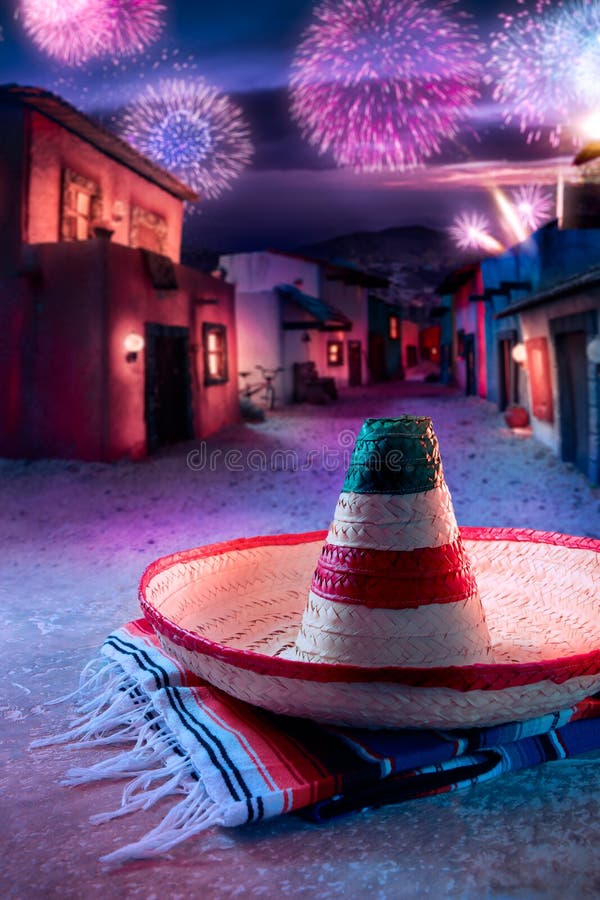 Mexican hat sombrero on a serape in a mexican village at twilight and fireworks