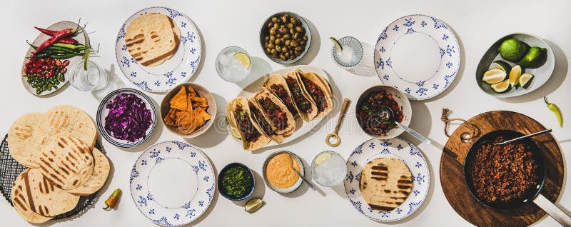 Mexican taco dinner with tomato salsa, tortillas and snacks