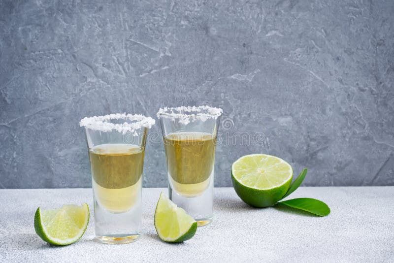 Mexican Tequila Gold in Short Glasses with Salt and Lime Slices Stock