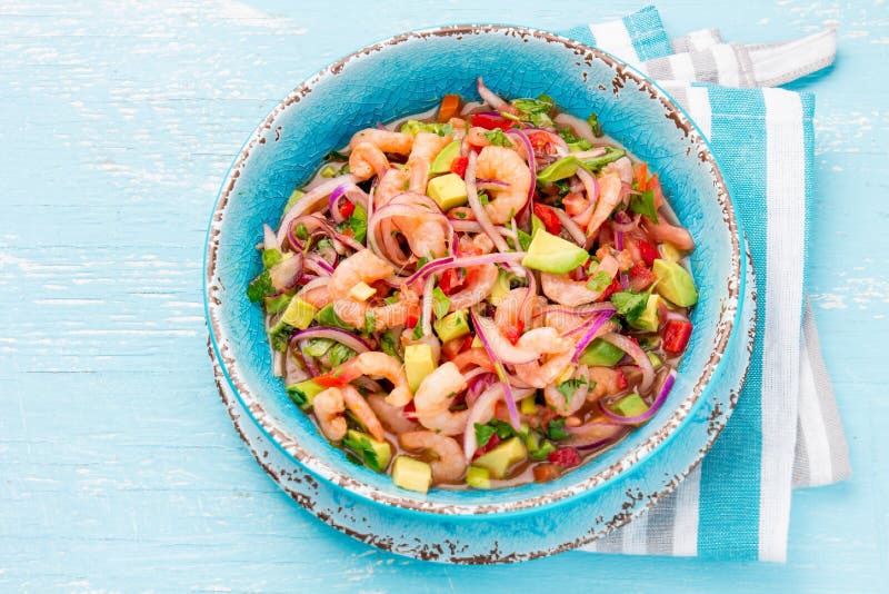 Mexikanische Nahrung Mexikanisches Garnelen ceviche sebiche mit Tomaten und Avocado in der blauen Schüssel, hölzerner blauer Hint lizenzfreies stockfoto Mexikanische Nahrung Mexikanisches Garnelen ceviche sebiche mit Tomaten und Avocado in der blauen Schüssel, hölzerner blauer Hint lizenzfreies stockfoto