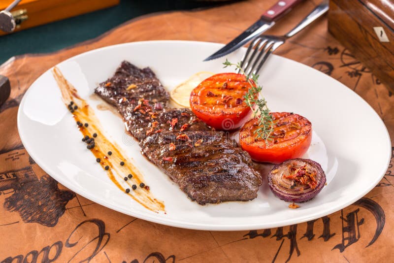 Mexikanisches gewürztes Rocksteak Arrachera mit gegrillten Tomaten und Zwiebel auf altem Kartenhintergrund stockfotos Mexikanisches gewürztes Rocksteak Arrachera mit gegrillten Tomaten und Zwiebel auf altem Kartenhintergrund stockfotos