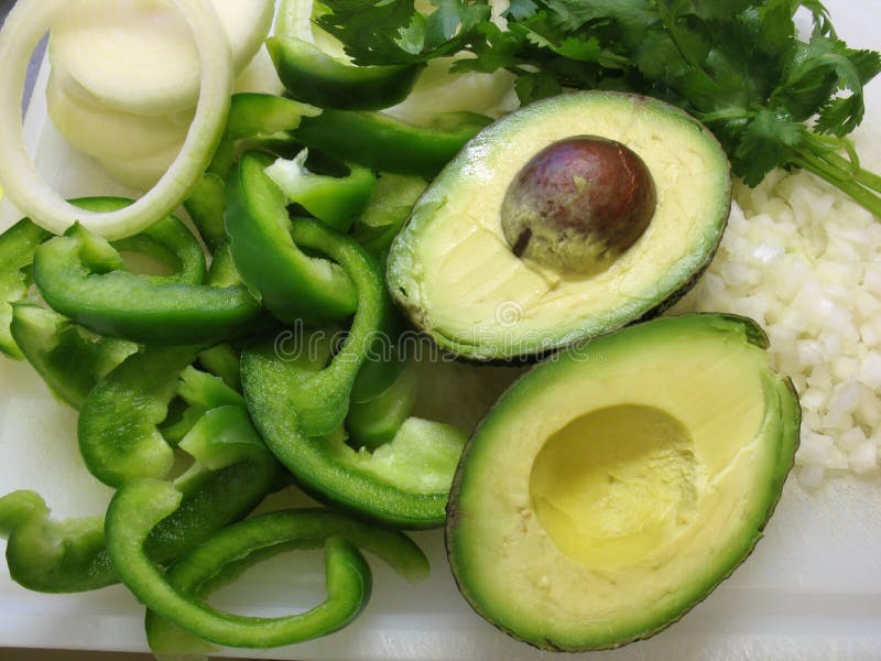 Photo of variety of ingredients for cooking Mexican food such as green pepper, onion, cilantro and avocado. Photo of variety of ingredients for cooking Mexican food such as green pepper, onion, cilantro and avocado.