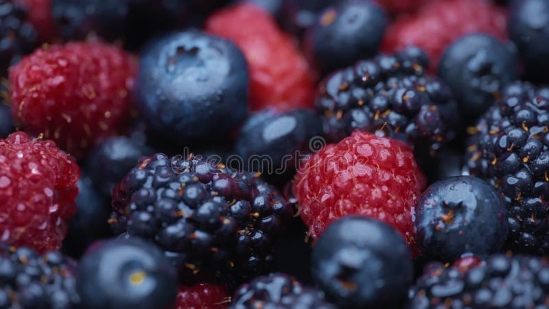 Mezcla de bayas orgánicas frescas con gotas de agua almacen de metraje de vídeo
