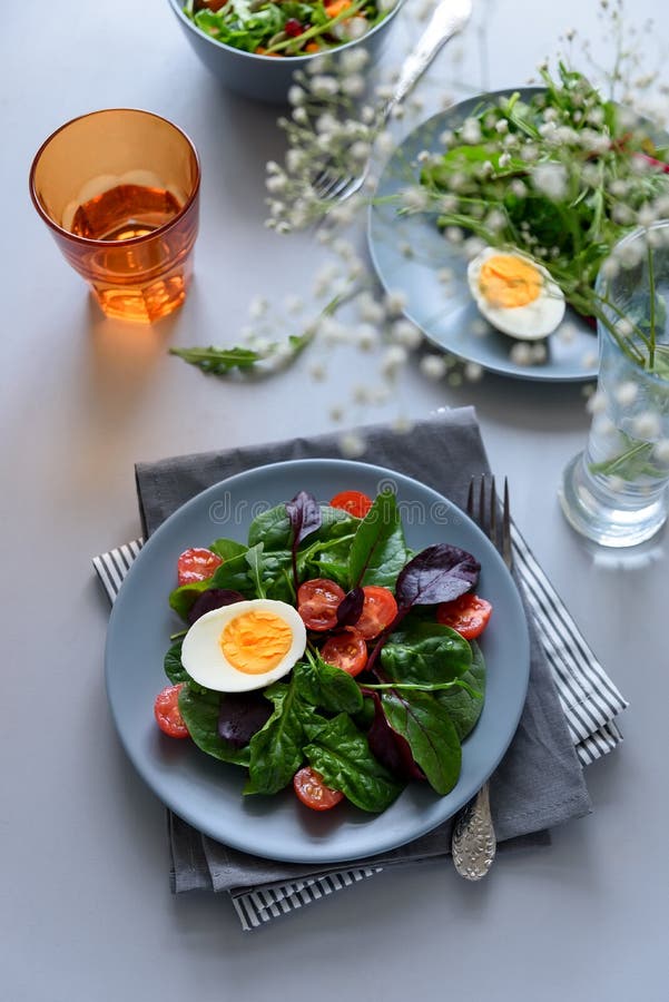 Mezcla de la ensalada con espinaca, arugula, hojas de la remolacha, tomates y huevos en fondo de madera gris Concepto vegetariano imagenes de archivo Mezcla de la ensalada con espinaca, arugula, hojas de la remolacha, tomates y huevos en fondo de madera gris Concepto vegetariano imagenes de archivo