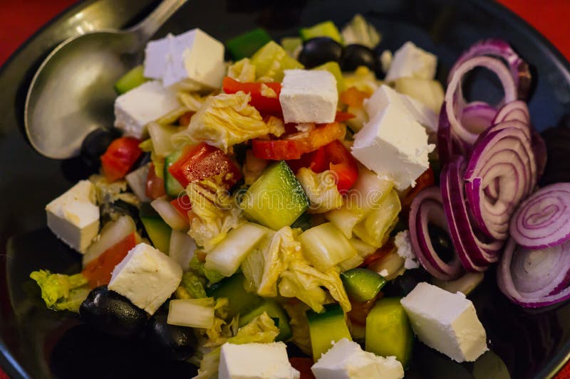 Mezcle la ensalada de las hojas con el paprika asado y pelado del tomate, y el queso feta vestido con aceite de oliva, ajo, y jug fotografía de archivo libre de regalías Mezcle la ensalada de las hojas con el paprika asado y pelado del tomate, y el queso feta vestido con aceite de oliva, ajo, y jug fotografía de archivo libre de regalías