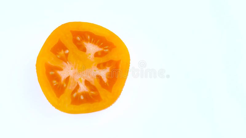 Mezza struttura di una vista superiore da sopra di un taglio in mezzo pomodoro di giallo arancio con le gocce di acqua Girando su