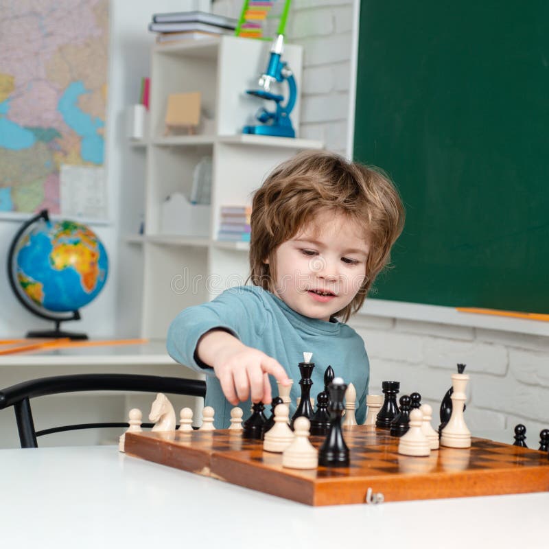 Escola de xadrez xadrez infantil concentrado jogo infantil inteligente  xadrez na biblioteca perto das estantes conceito educacional menino  pensando em xadrez o conceito de aprender e crescer crianças