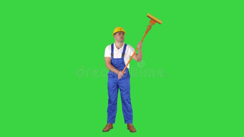 Mi fenêtre adulte de sourire de nettoyage de travailleur avec la racle et sourire à la caméra sur un écran vert, clé de chroma clips vidéos