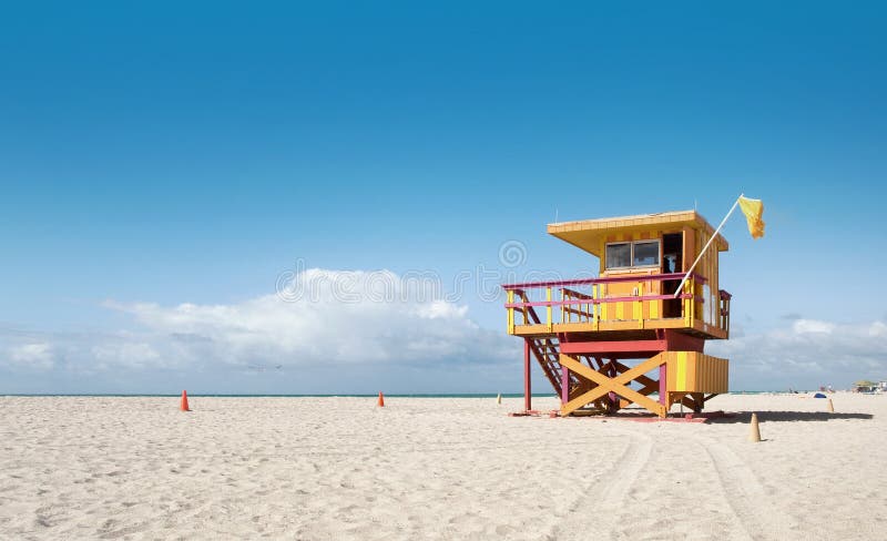 Miami Beach Florida, lifeguard house in a typical colorful Art Deco style on a sunny summer day, with blue cloudy sky and Atlantic Ocean in the background. World famous travel location.