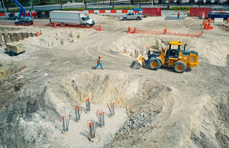 Miami, de V.S. - 30 Oktober, 2015: arbeiders en machines op bouwkuil De bouwterreinwerken aangaande zonnige openlucht royalty-vrije stock afbeelding Miami, de V.S. - 30 Oktober, 2015: arbeiders en machines op bouwkuil De bouwterreinwerken aangaande zonnige openlucht royalty-vrije stock afbeelding
