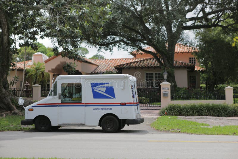 Miami, Florida, USA 2.09.2020 - USPS Post Office Mail Truck parked in front of Mediterranean architecture style house in. Miami, Florida, USA 2.09.2020 - USPS Post Office Mail Truck parked in front of Mediterranean architecture style house in