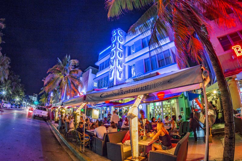 people enjoy the evening in the Columbus restaurant next to famous art deco hotel colony at ocean drive, Miami