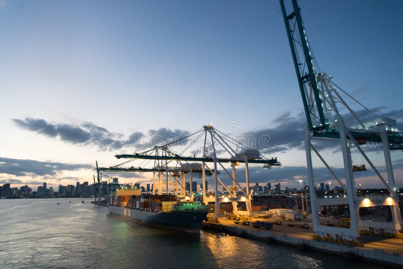 Miami, USA - March 01, 2016: cargo ship and cranes in sea port on evening sky. Maritime container port or terminal. Shipping freig stock photography Miami, USA - March 01, 2016: cargo ship and cranes in sea port on evening sky. Maritime container port or terminal. Shipping freig stock photography