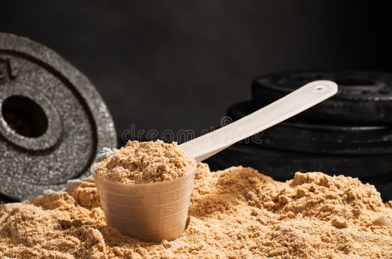 Miarka serwatki proteina na czarnym tle Czekoladowy flawour obraz stock Miarka serwatki proteina na czarnym tle Czekoladowy flawour obraz stock