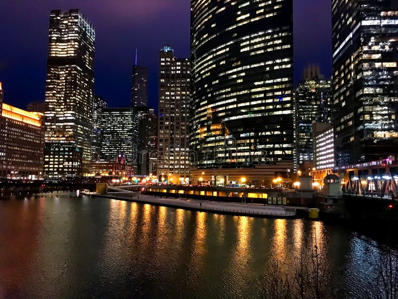 Miasto nocy światła odbijają na prawie marznącej Chicagowskiej rzece w pętli podczas zimy evening godzinę szczytu