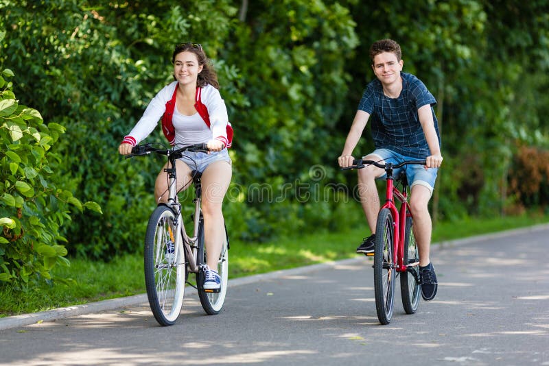 Miastowy bicykl - nastoletniej dziewczyny i chłopiec kolarstwo obraz stock Miastowy bicykl - nastoletniej dziewczyny i chłopiec kolarstwo obraz stock