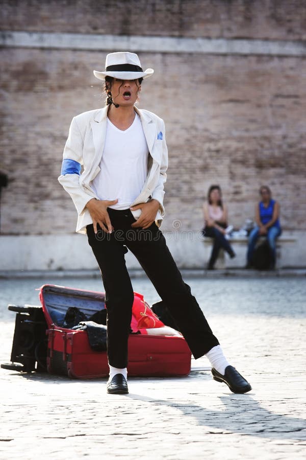 A Michael Jackson impersonator is performing in a square. Her clothes are those worn in smooth criminal by the famous singer who died. Location: Piazza del Popolo (Rome, Italy). A Michael Jackson impersonator is performing in a square. Her clothes are those worn in smooth criminal by the famous singer who died. Location: Piazza del Popolo (Rome, Italy).