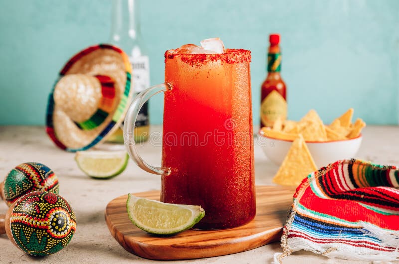 Michelada - Mexican alcoholic cocktail with beer, lime juice, tomato juice, spicy sauce and spices