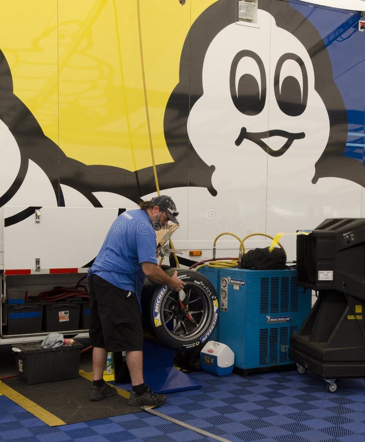 Michelin Tire Technician Balances Wheel fotografia de stock Michelin Tire Technician Balances Wheel fotografia de stock