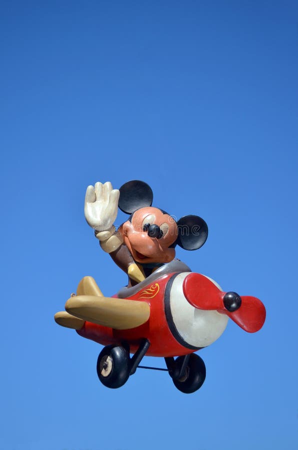 Mickey Mouse Disney figure part of a huge private collection of big figs and original Disney store display figures. Mickey Mouse is flying a aeroplane with a blue sky background