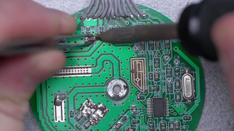 Microcircuit étant fixé avec le fer à souder Concept de réparation d'ordinateur Brucelles avec la puce et le fer à souder soudure