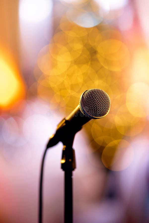 Microfone isolado do bokeh em uma fase do concerto com os artistas redy a executar no de bastidores fotos de stock royalty free Microfone isolado do bokeh em uma fase do concerto com os artistas redy a executar no de bastidores fotos de stock royalty free