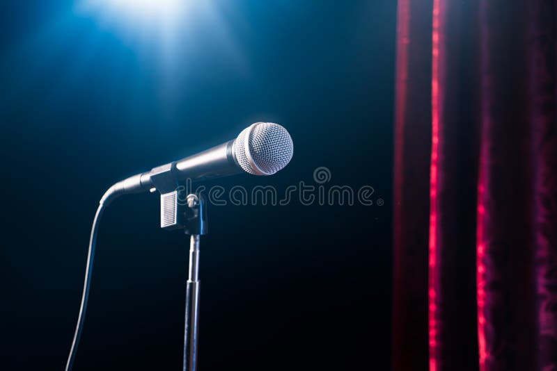 Microfono del supporto su una fase della commedia su con il raggio dei riflettori, immagine ad alto contrasto