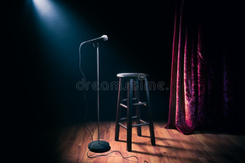 Microfono e panchetto di legno del supporto su una fase della commedia su con il raggio dei riflettori, immagine ad alto contrast