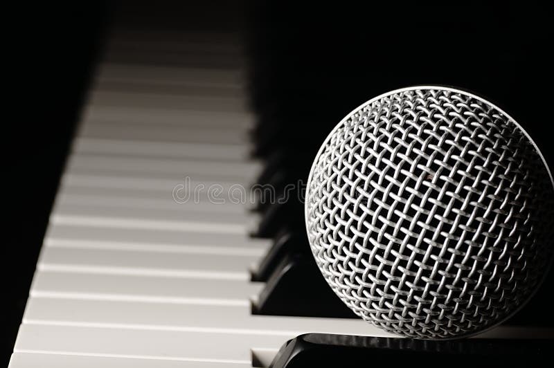 Microfoon op een pianotoetsenbord stock afbeelding Microfoon op een pianotoetsenbord stock afbeelding