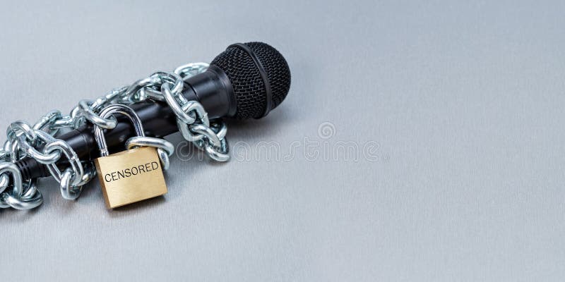 Microphone in Metallic Chains and Lock on Grey Surface. Stock Image