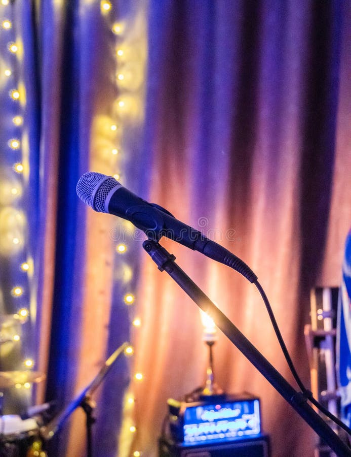 Microphone and stage light. Public performance on stage Microphone on stage against a background of auditorium. Shallow depth of stock images