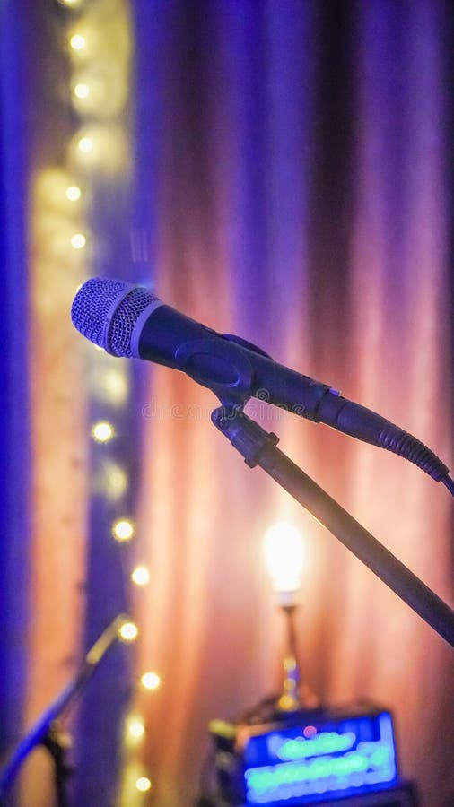 Microphone and stage light. Public performance on stage Microphone on stage against a background of auditorium. Shallow depth of royalty free stock photo