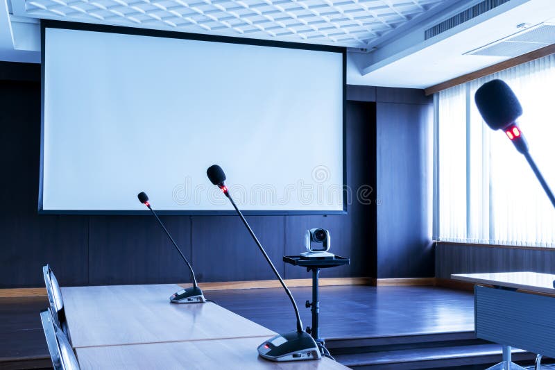 Microphone on Table with Projector Screen Background in Meeting Room