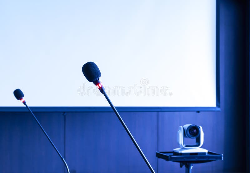 Microphone on Table with Projector Screen Background in Meeting Room