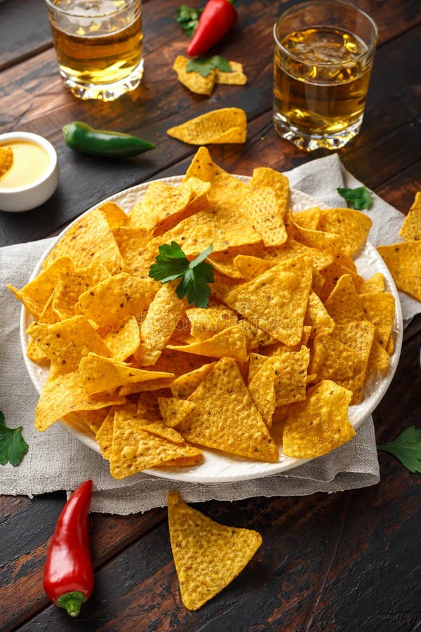 Microplaquetas dos nachos da tortilha com mergulho do molho de queijo, do guacamole e da salsa dos tomates Vidro da cerveja fotografia de stock royalty free Microplaquetas dos nachos da tortilha com mergulho do molho de queijo, do guacamole e da salsa dos tomates Vidro da cerveja fotografia de stock royalty free