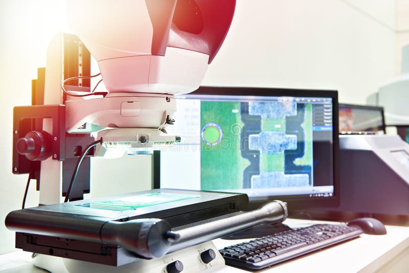 Microscopio di misurazione alle parti di controllo nella fabbricazione fotografia stock Microscopio di misurazione alle parti di controllo nella fabbricazione fotografia stock