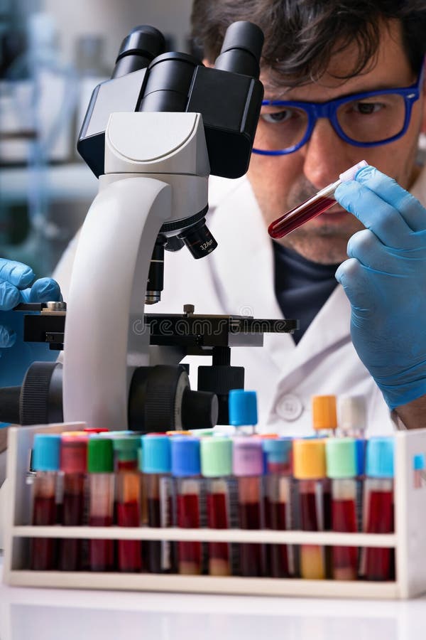 Microscopist Scientist Analyzing Blood Sample in Microscope in the