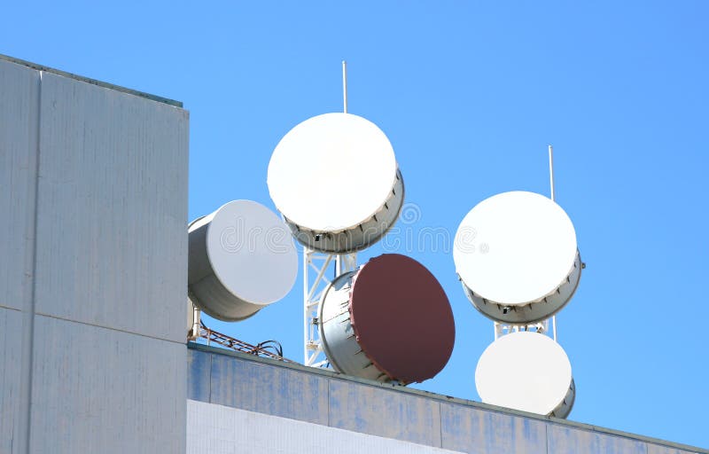El gran comunicación antena sobre el techo de comercial el edificio.