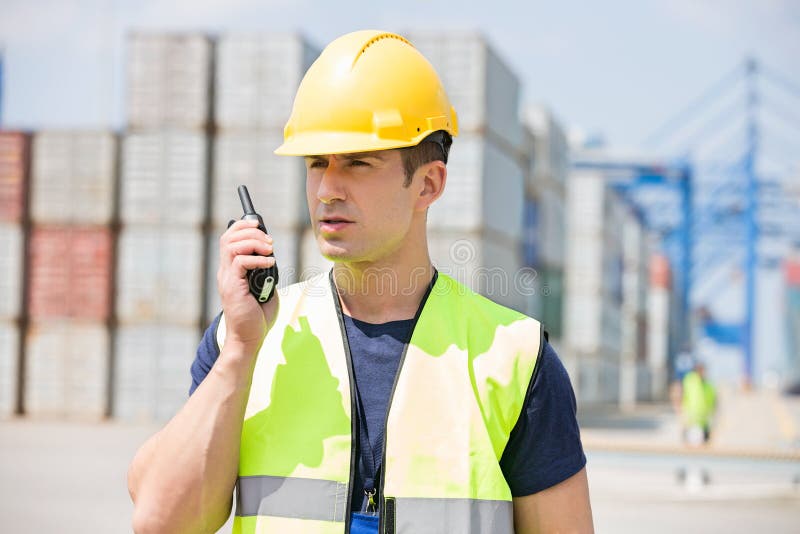 Mid Adult Man Using Walkie-talkie in Shipping Yard Stock Photo - Image ...