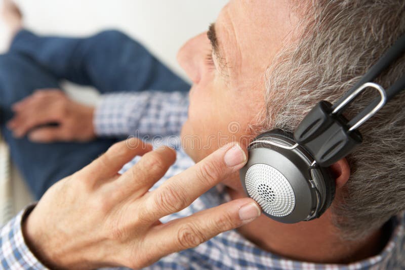 Mid ag mens die aan muziek door hoofdtelefoons luistert royalty-vrije stock fotografie Mid ag mens die aan muziek door hoofdtelefoons luistert royalty-vrije stock fotografie