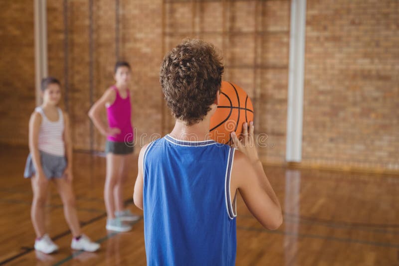 Middelbare schooljongen ongeveer om een strafschop te nemen terwijl het spelen van basketbal stock afbeelding Middelbare schooljongen ongeveer om een strafschop te nemen terwijl het spelen van basketbal stock afbeelding