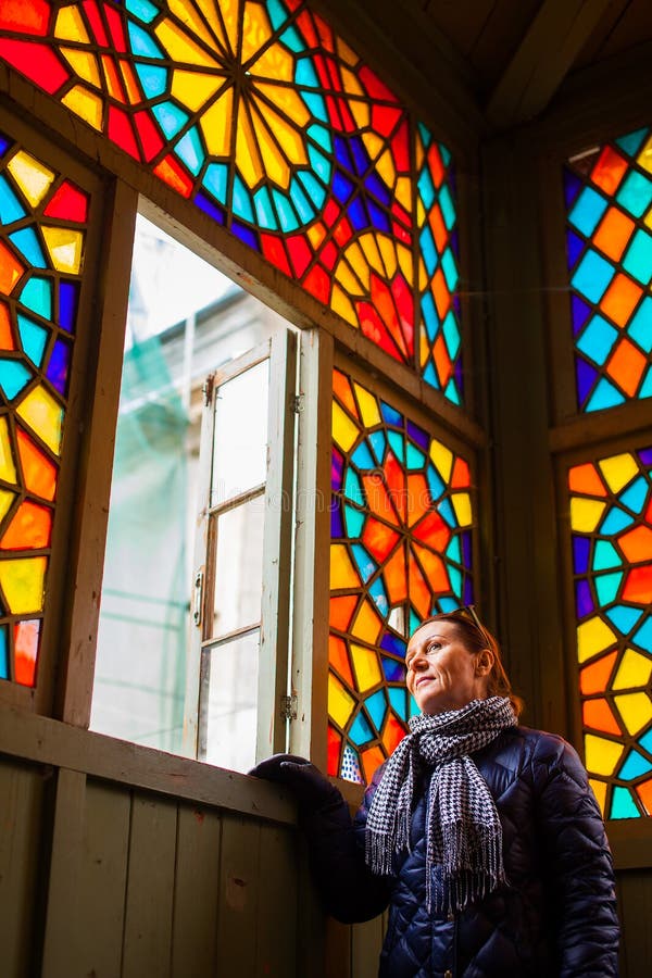 Midden oude vrouw die door venster met multi-coloured gebrandschilderd glas, Oud Tbilisi, Georgië, Januari 2019 kijken royalty-vrije stock afbeeldingen Midden oude vrouw die door venster met multi-coloured gebrandschilderd glas, Oud Tbilisi, Georgië, Januari 2019 kijken royalty-vrije stock afbeeldingen