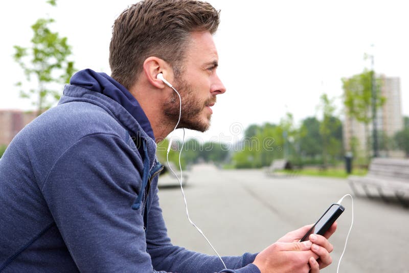 Middle Age Active Male Sitting And Listening To Music Stock Photo