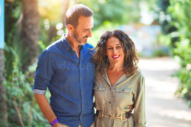 Middle age beautiful couple smiling happy and confident at town park