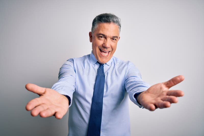 Middle age handsome grey-haired business man wearing elegant shirt and tie smiling cheerful offering hands giving assistance and