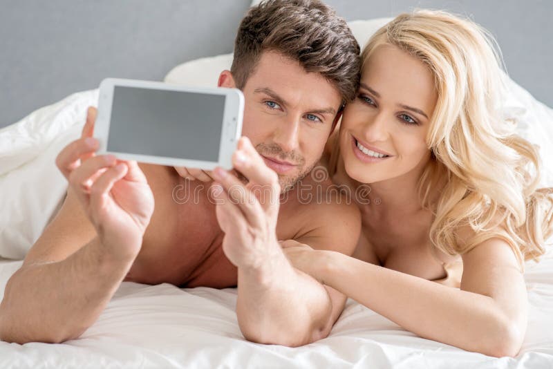 Middle Age Sweet Lovers Taking Photos on Bed