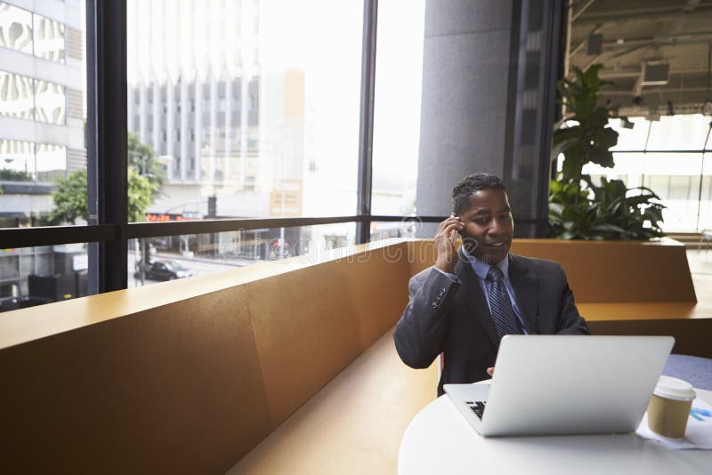 Middle aged black businessman using phone in a modern office royalty free stock photo Middle aged black businessman using phone in a modern office royalty free stock photo