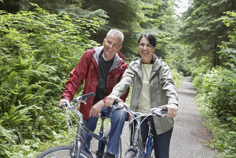 Middle Aged Couple With Bikes In Forest