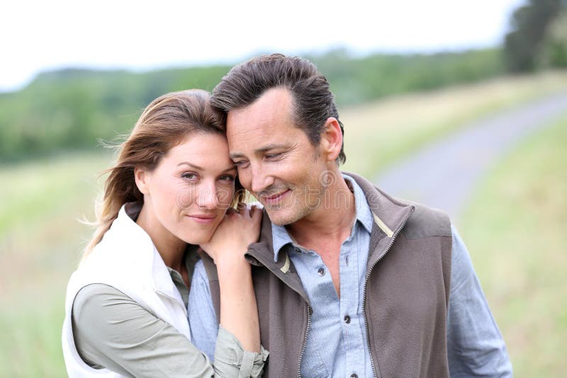 Middle-aged couple on countryside feeling serene stock photo Middle-aged couple on countryside feeling serene stock photo